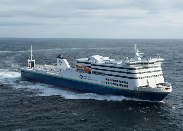The Marine Atlantic MV Blue Puttees ferry sails the whitecaps of the Atlantic Ocean on a clear but windy day. 